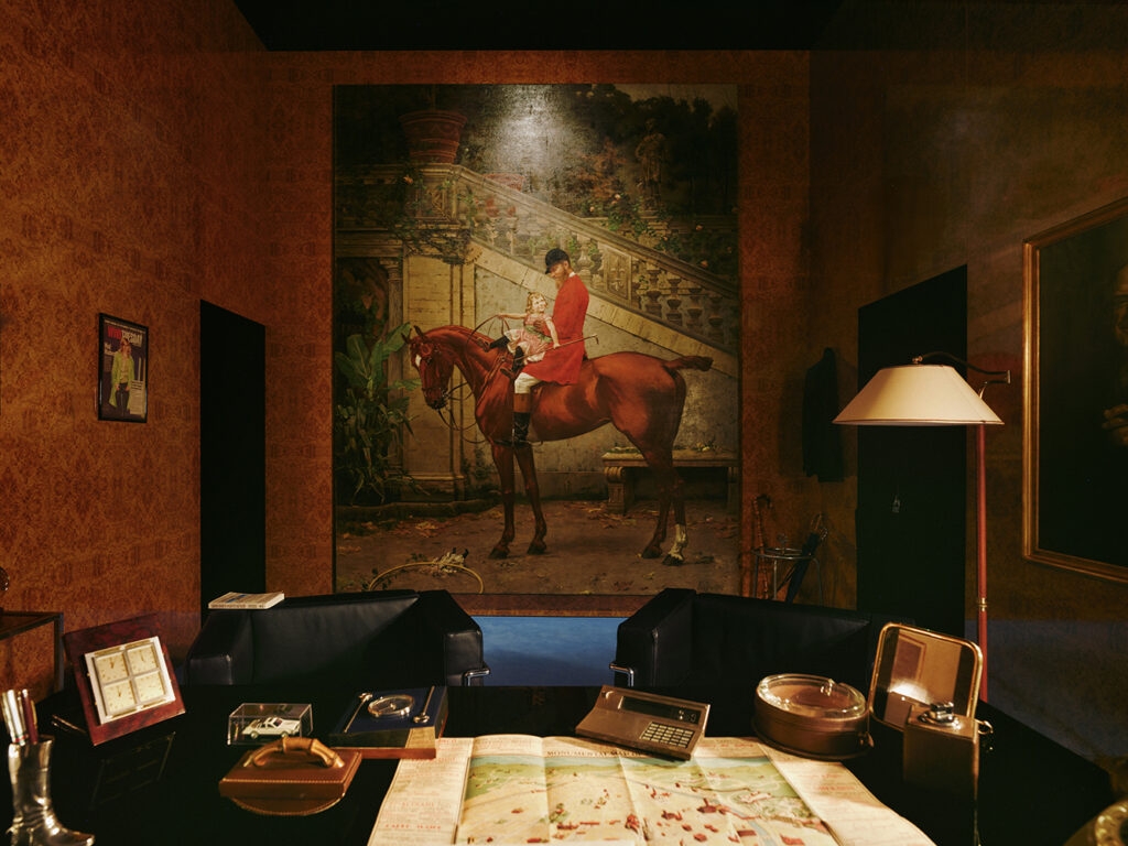 《Gucci Storia》展览"秘闻之间"空间，复刻20世纪80年代纽约Gucci贵宾室氛围，中央陈设古董文具、地图与马术主题油画