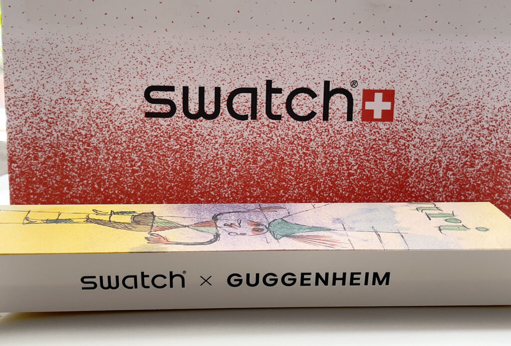 Swatch x Guggenheim 系列腕表，表盘与哑光透明表带饰有保罗·克利 (Paul Klee) 艺术作品《The Bavarian Don Giovanni》印花。