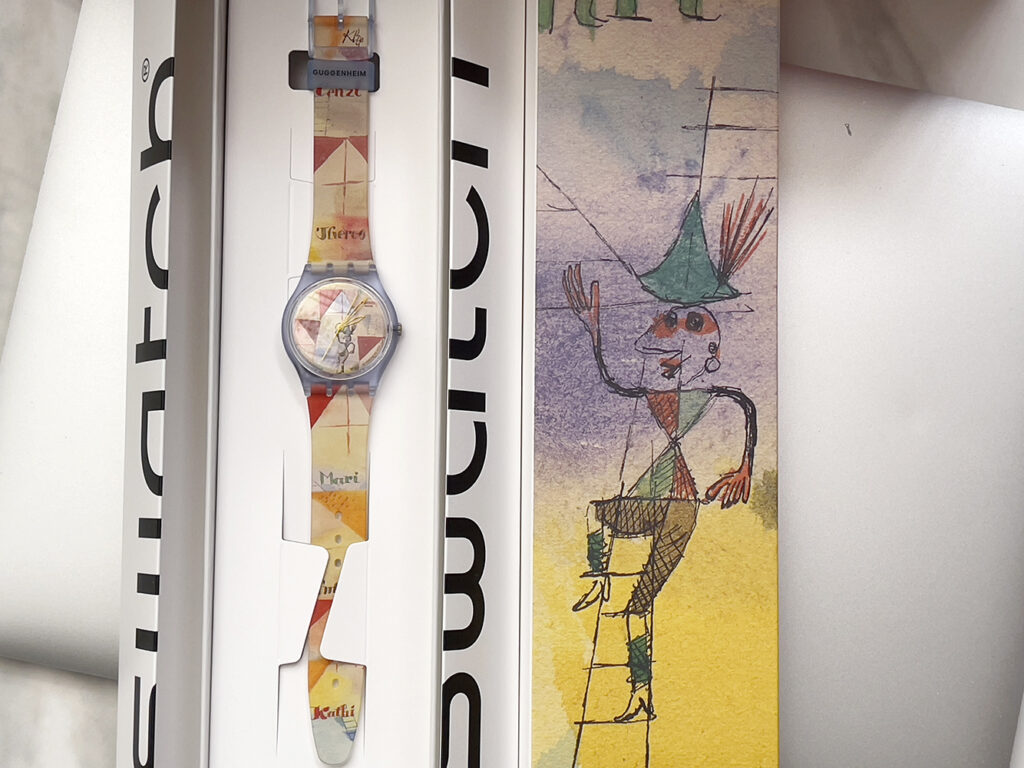 Swatch x Guggenheim 系列腕表，表盘与哑光透明表带饰有保罗·克利 (Paul Klee) 艺术作品《The Bavarian Don Giovanni》印花。